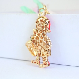Cartoon Santa keychain pendant in gold metal with heart cutouts and red enamel details