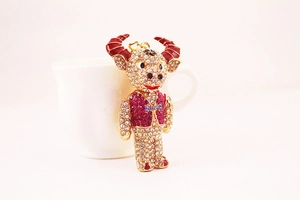 Close-up of rhinestone ox keychain with red horns and blue bow tie on ceramic cup