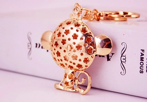 Detailed macro shot of golden monkey keychain with hollow floral pattern on a book