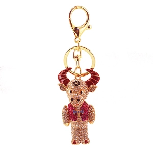 Close-up of rhinestone ox keychain with red enamel horns and sparkling crystal details