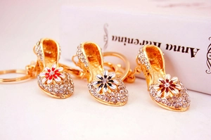 Detail of high heel keychains with sparkling rhinestones and colorful enamel flowers