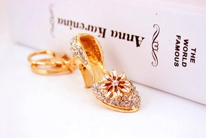 Detailed close-up of a gold stiletto keychain featuring crystal rhinestones and enamel flower
