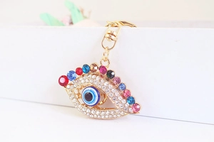 Vue macro d'un porte-clés œil grec avec strass colorés et cadre en alliage doré