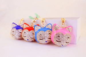 Detail of four colorful crystal-studded fox head keychains with golden hardware