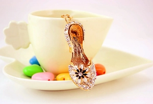 Detail of high heel charm with clear rhinestones and daisy flower on gold metal keyring