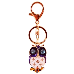 Porte-clés hibou doré avec émail violet et grands yeux en cristal bleu sur fond blanc