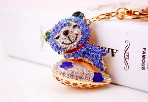 Detail of a sparkling crystal-encrusted blue bear keychain with a golden heart base