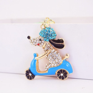 Llavero de perro en moto con diamantes de imitación azules y base metálica dorada