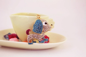 Dettaglio del portachiavi a forma di cane con strass luccicanti blu e viola e finitura oro