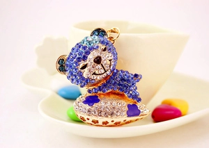 Detailed close-up of a blue crystal bear keychain with rhinestone heart and gold frame