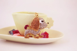 Dettaglio ravvicinato di un portachiavi a forma di cane con strass rosa e ambra
