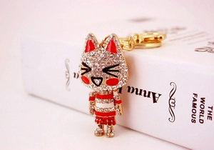 Close-up of sparkling rhinestone-encrusted cartoon fox keychain with red enamel details