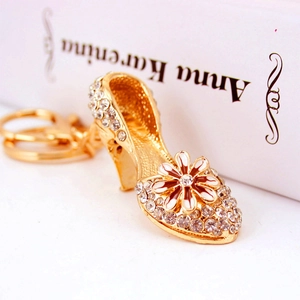 Elegant gold high heel keychain with sparkling rhinestones and daisy flower charm detail