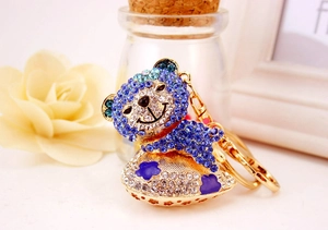 Close-up of royal blue crystal bear keychain with rhinestone heart and gold plating