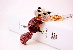 Détail d'un porte-clés renard orné de strass violets et blancs sur alliage doré