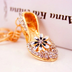 Golden high heel keychain with white rhinestones and a small daisy flower charm