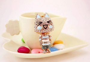 Macro detail of cute cat keychain with blue and white rhinestones and golden hook