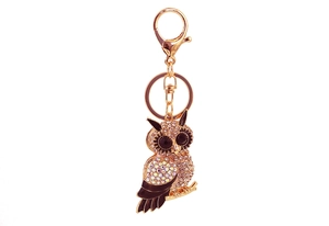 Macro detail of golden owl keychain with sparkling rhinestones and lobster clasp