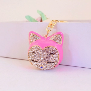 Pink enamel cat head keychain with white rhinestones and a gold metal ring for bags