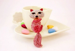 Détail d'un porte-clés renard rose orné de strass brillants sur une base dorée