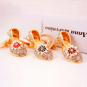 Charming rhinestone high heel keychain with daisy flower accents and golden alloy finish