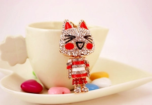 Gros plan d'un porte-clés chat scintillant avec oreilles rouges dans une tasse