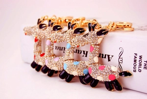 Détail de quatre porte-clés girafe en émail coloré avec strass brillants et fermoirs mousquetons