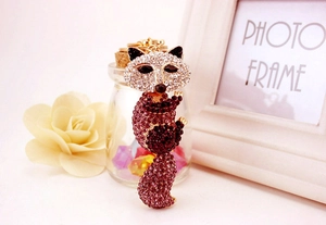 Détail macro d'un porte-clés raton laveur serti de strass avec base en or rose