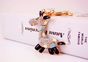 Détail du porte-clés girafe avec strass blancs et émail bleu sur métal doré