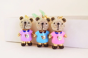 Vue détaillée de trois adorables porte-clés ours incrustés de strass en rose, bleu et violet