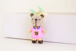 Détail d'un porte-clés ourson mignon avec strass brillants et robe en émail rose élégante