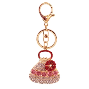 Goldener Handtaschen-Schlüsselanhänger mit rosa-weißen Strasssteinen und Kristallblume