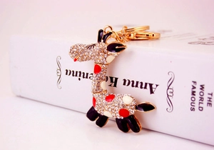 Détail d'un porte-clés girafe doré orné de strass blancs et de finitions en émail coloré