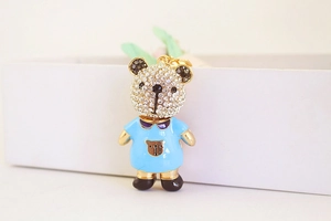 Détail d'un pendentif ours en peluche avec strass brillants et émail bleu élégant