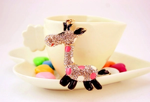 Détail du pendentif girafe avec cristaux brillants et émail coloré sur une tasse