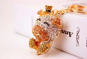 Macro detail of a crystal-encrusted bear keychain with a stylish black top hat