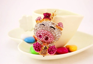 Detail of crystal pink pig keychain with shimmering rhinestones and a gold metal hook