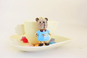 Détail d'un charm ours mignon en strass avec émail bleu sur une tasse en céramique