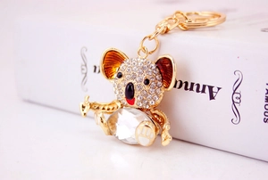Close-up of cute koala keychain with sparkling crystals and golden metal chain