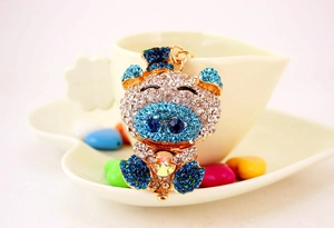Detailed view of crystal pig keychain with blue rhinestones and iridescent center stone