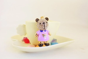 Détail du porte-clés ours avec cristaux blancs et robe en émail violet pour cadeau