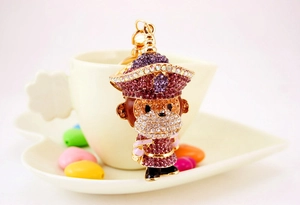 Gros plan détaillé d'un porte-clés singe en strass étincelants violets et dorés