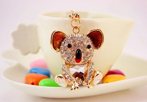 Detail of crystal koala keychain featuring sparkling rhinestones on a white ceramic cup