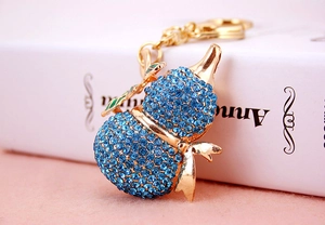 Dettaglio del portachiavi Wu Lou dorato con strass blu cielo e foglia decorativa