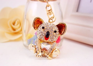Close-up of golden koala keychain with sparkling crystals and large heart-shaped gemstone