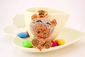 Macro shot of a crystal-encrusted golden pig keychain with a heart gem and hat detail