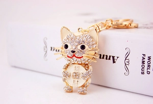 Macro shot of gold cat keychain featuring crystal rhinestones and lucky coin detail