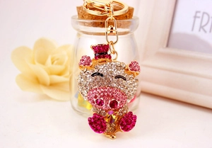 Close-up of cute crystal pig keychain with pink rhinestones and golden metal ring