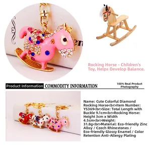 Detail of crystal-encrusted rocking horse keychains in pink, red, and white finishes