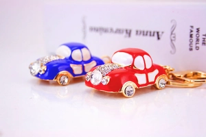 Detail of colorful rhinestone car keychains in blue and red with gold-tone metal hooks